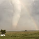 Incredible sight: colossal tornado intersects with a rainbow