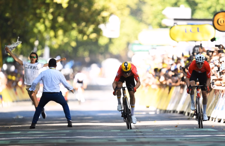 A person opposing Israel is subdued by security personnel at the conclusion of the Tour de France.